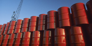 Red metal barrels against blue sky.